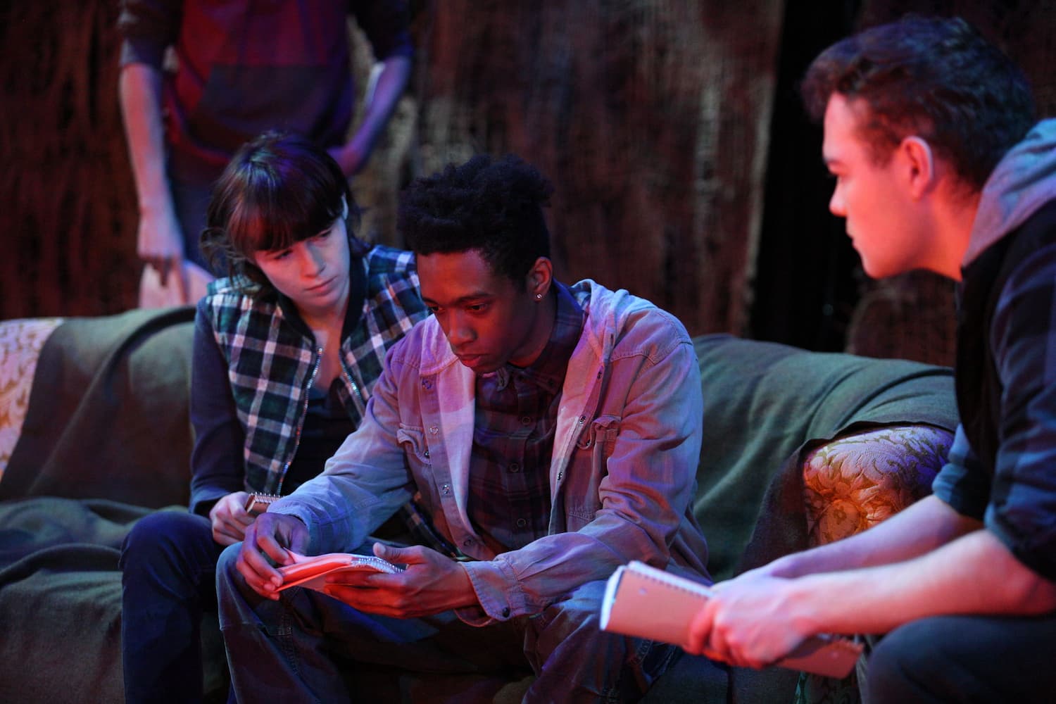 solemn scene of three actors on a couch