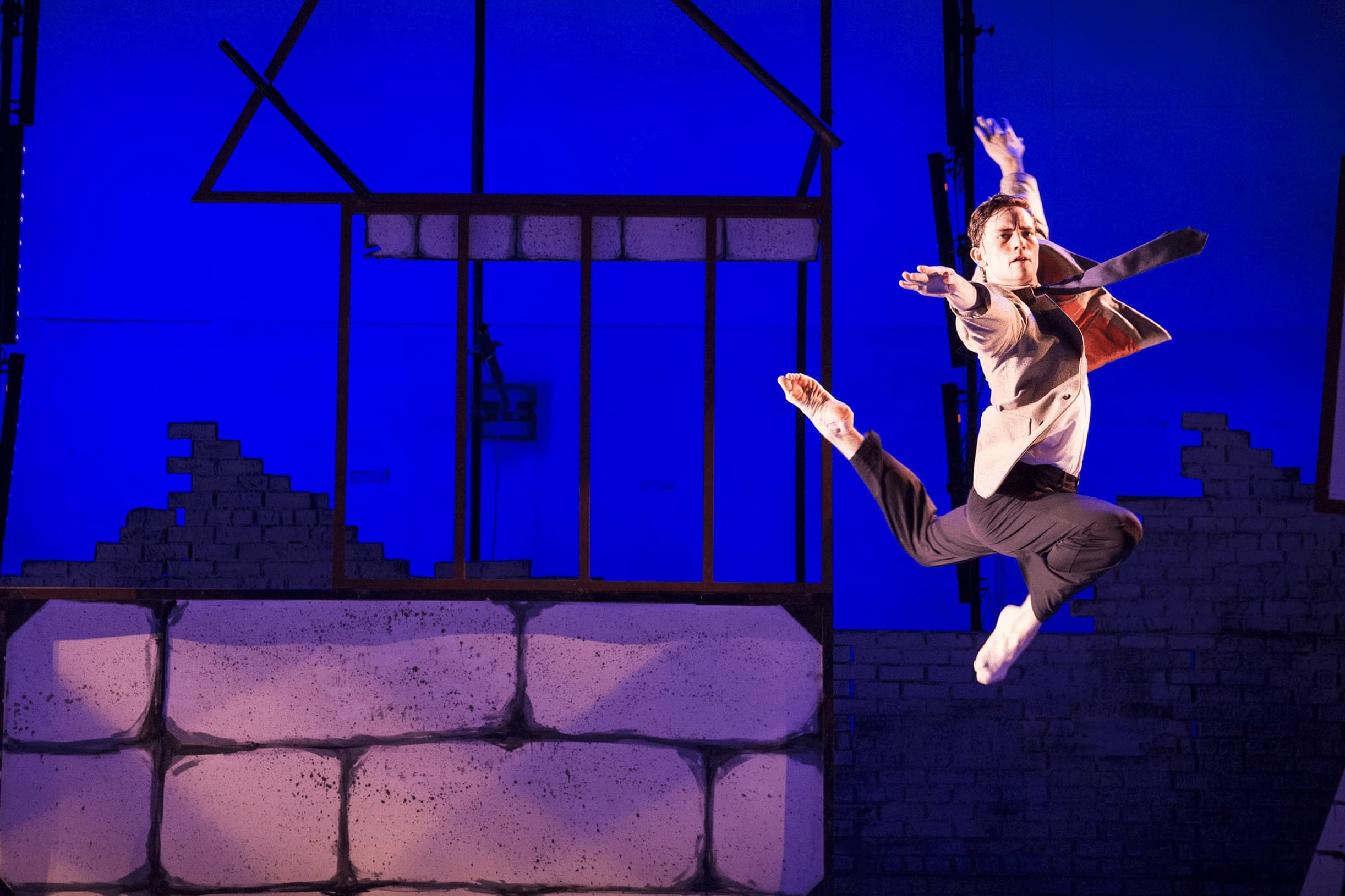 A single dancer on stage takes an artful leap