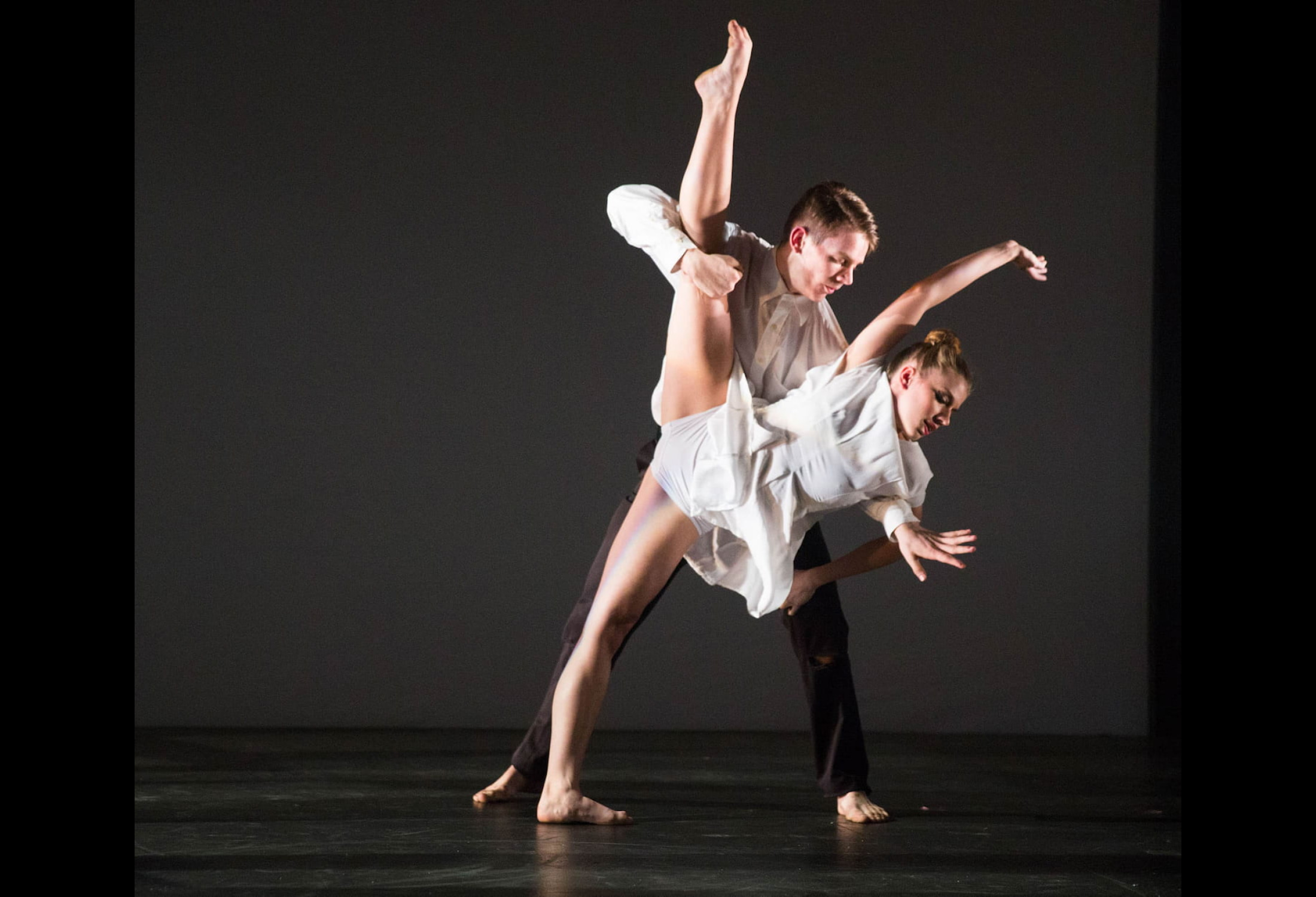 A dancing duet with one dancer supporting the standing splits of the foremost of the pair