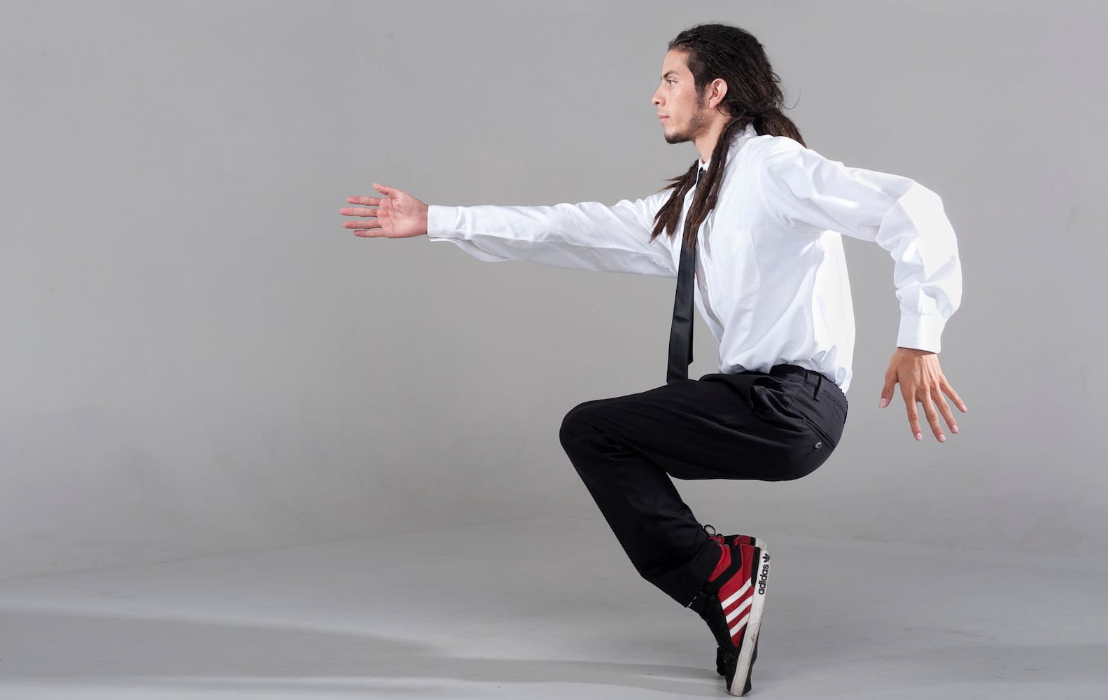 Dancer balances on toes with one arm raised