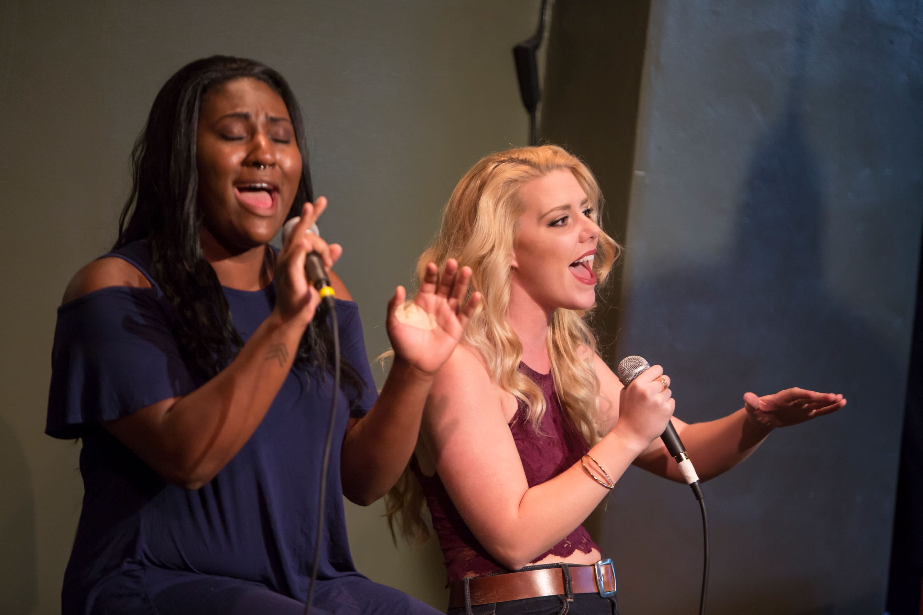 A harmonizing pair of singers gesture in support of the their own voices